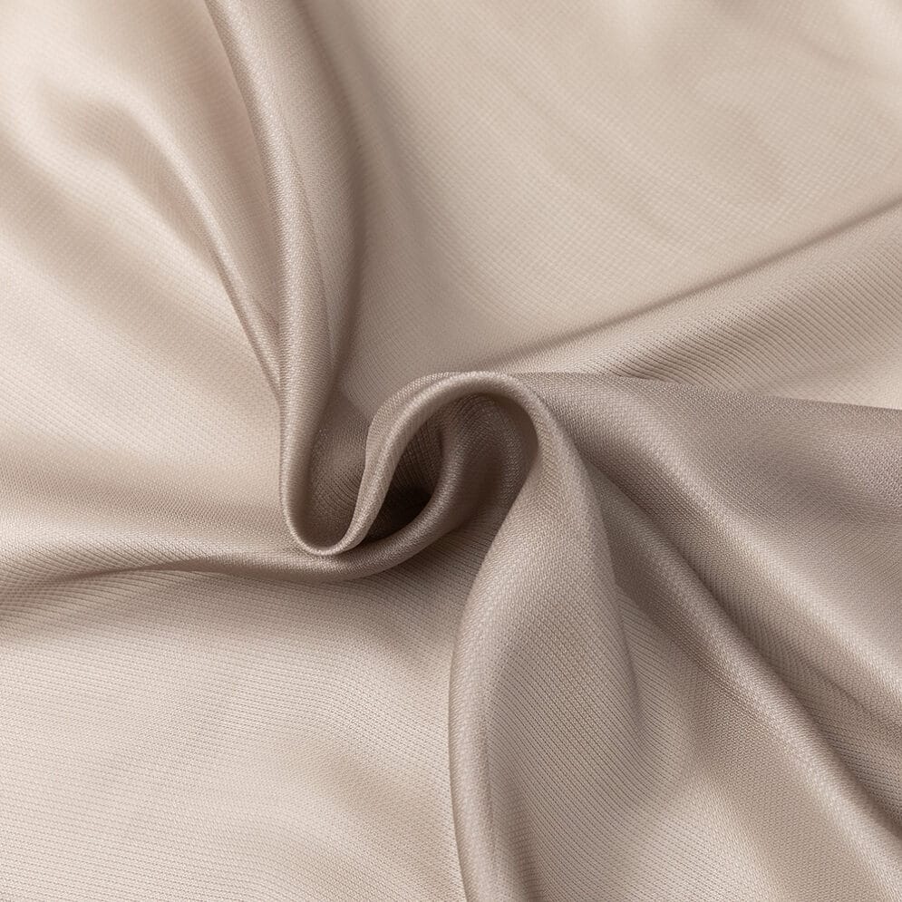 Detail van taupekleurige stof met glans en plooien.