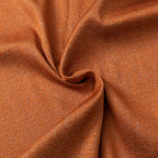 Detail van oranje stof met glans en plooien.