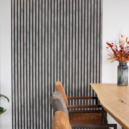 Lamellenwand naast een eettafel.