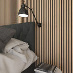 Verticale lamellenwand achter een bed.