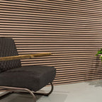 Horizontale lamellenwand achter een fauteuil.