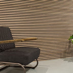Horizontale lamellenwand achter een fauteuil.