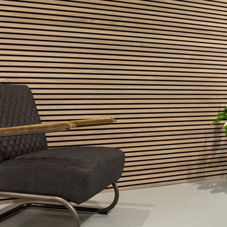 Horizontale lamellenwand achter een fauteuil.