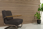Horizontale lamellenwand achter een fauteuil.
