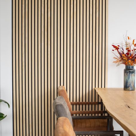 Lamellenwand naast een eettafel.