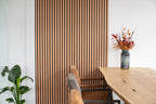 Lamellenwand naast een eettafel.