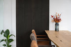 Lamellenwand naast een eettafel.
