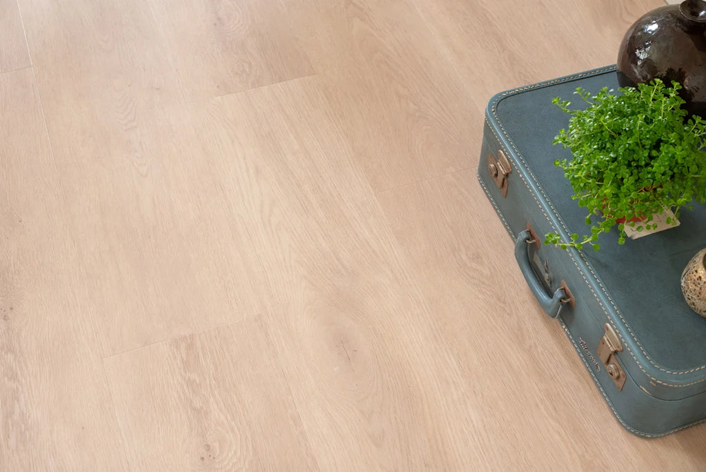 Vloer met rechte planken naast decoratie en een plant.