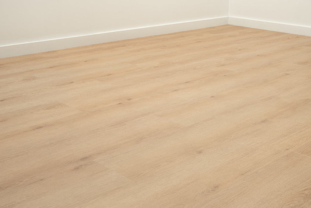 Vloer met rechte planken in een hoek met witte plinten.