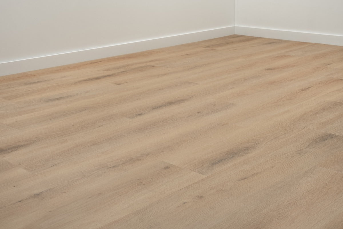 Vloer met rechte planken in een hoek met witte plinten.