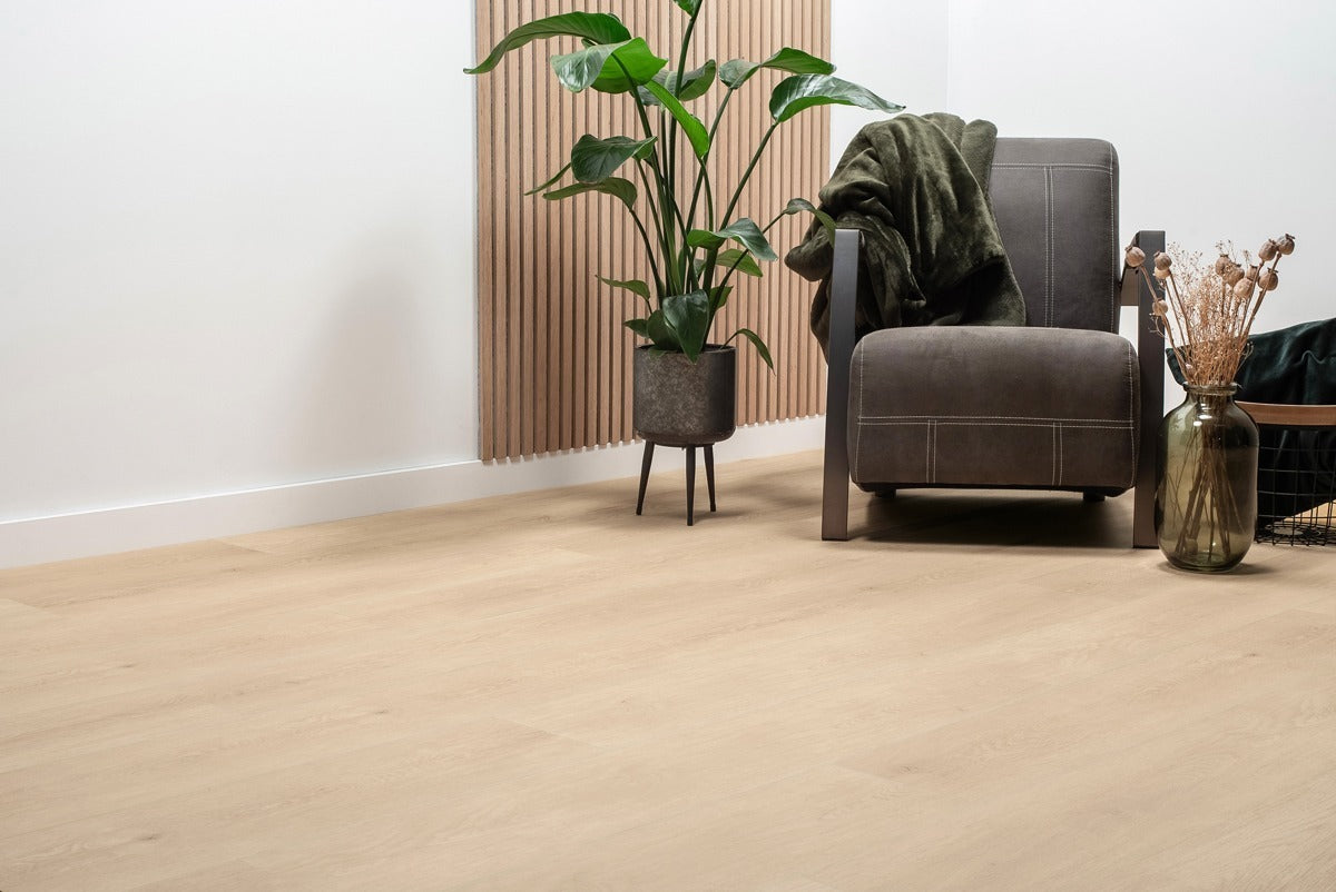 Vloer met rechte planken bij een fauteuil en een grote plant.