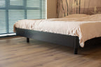 Vloer met rechte planken naast een bed.