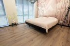 Vloer met rechte planken naast een bed.