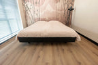 Vloer met rechte planken naast een bed.