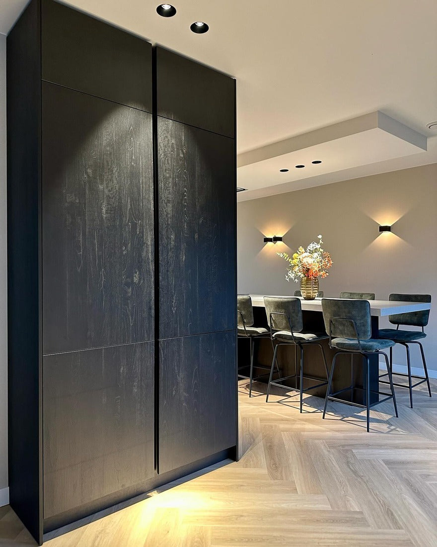 Interieur met een donker wandmeubel en een lichte vloer.