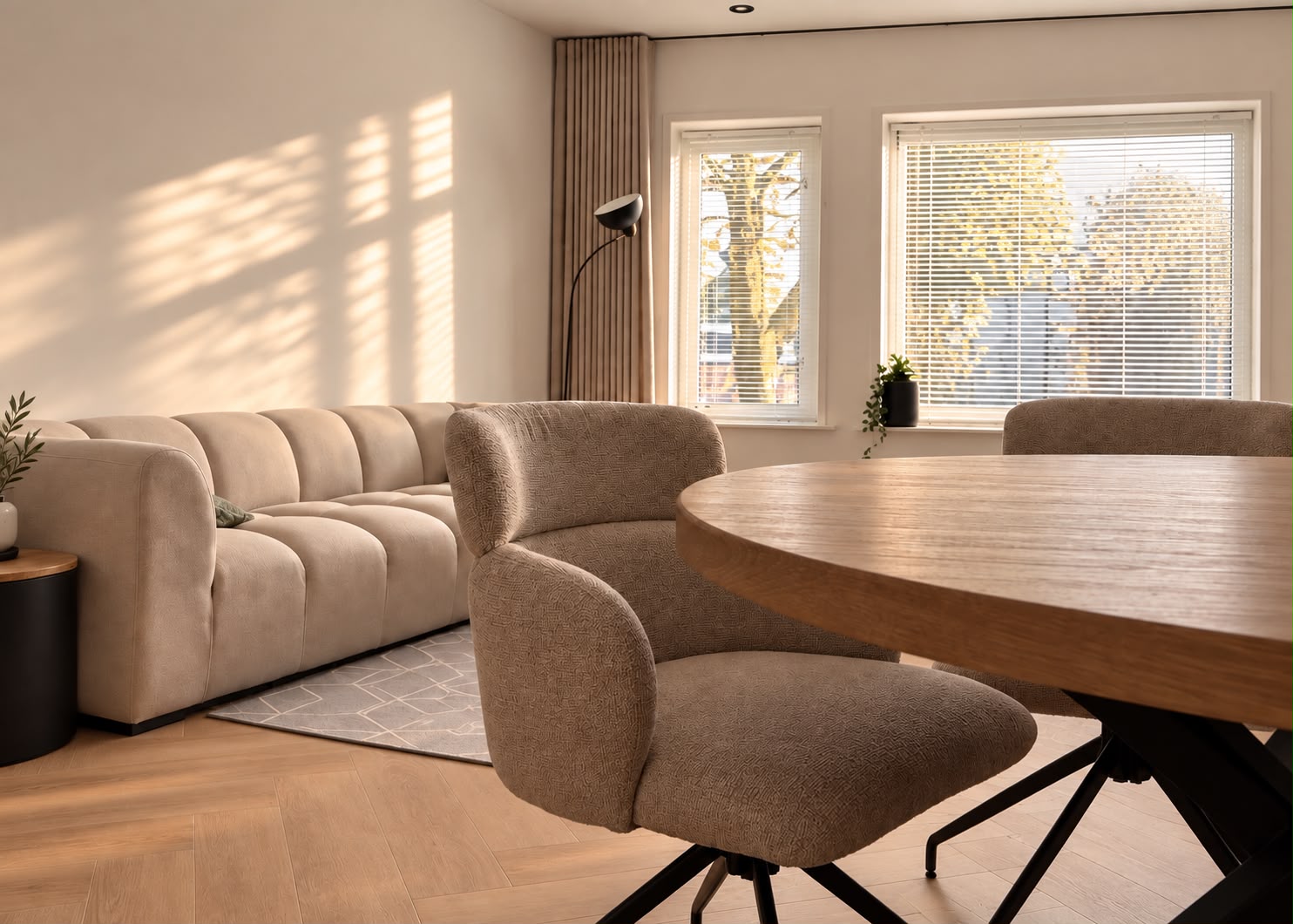 Sfeerbeeld van een woonkamer met een lichte bank en houten vloer