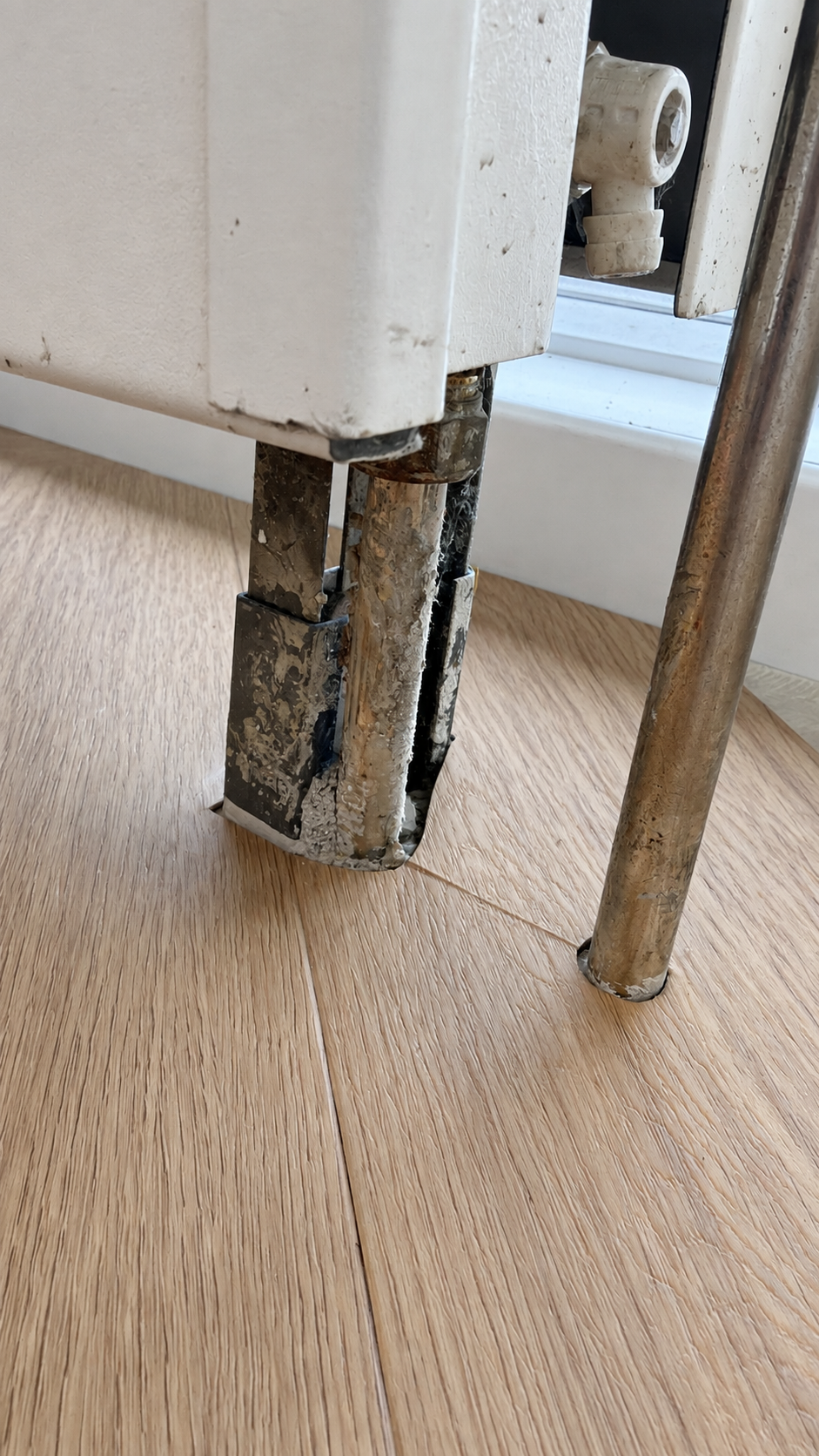 Detail van de vloeruitsparing rond radiatorsteun en leiding bij 050-IT