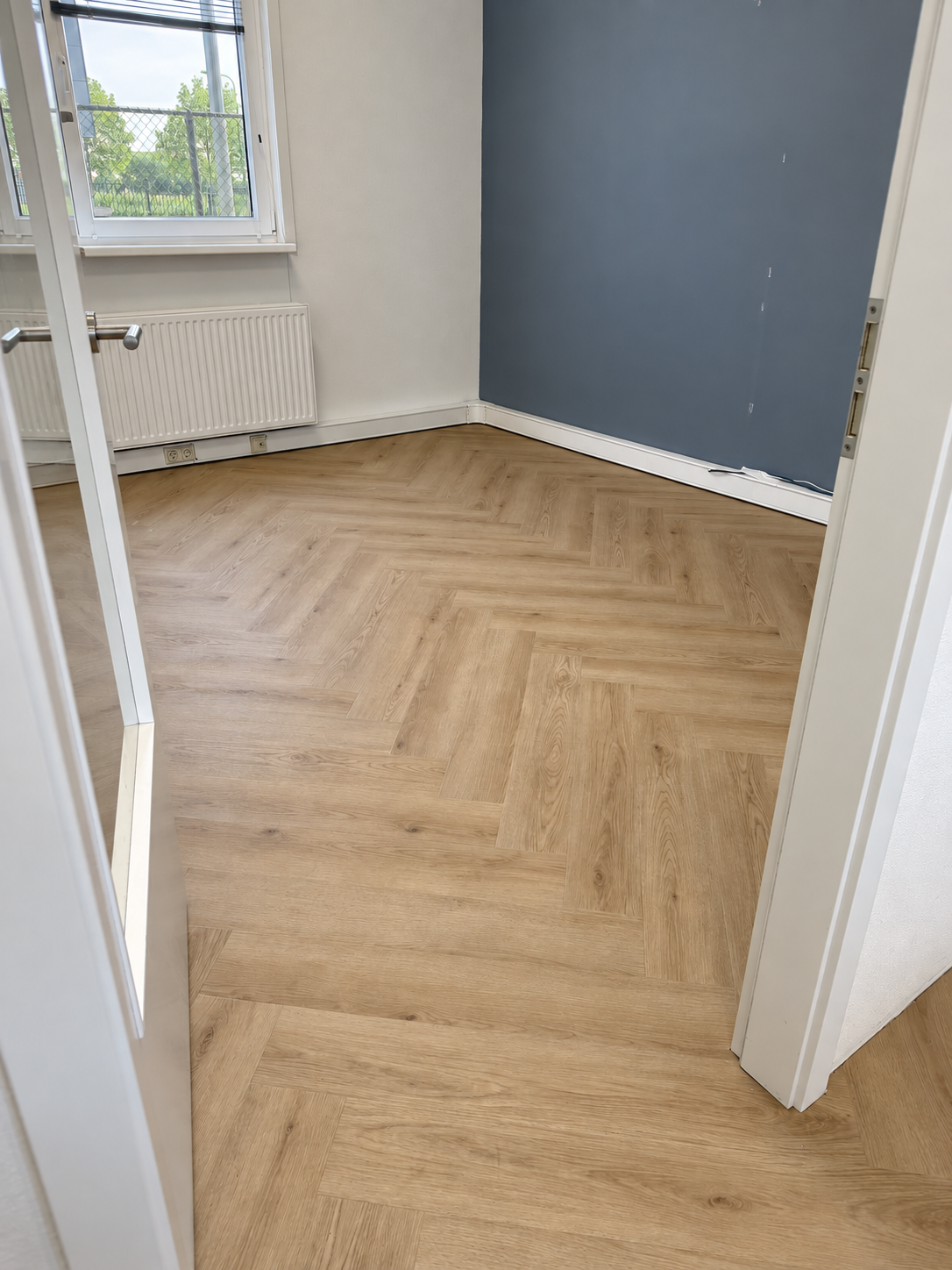 Doorlopende walvisgraatvloer bij een deuropening van 050-IT