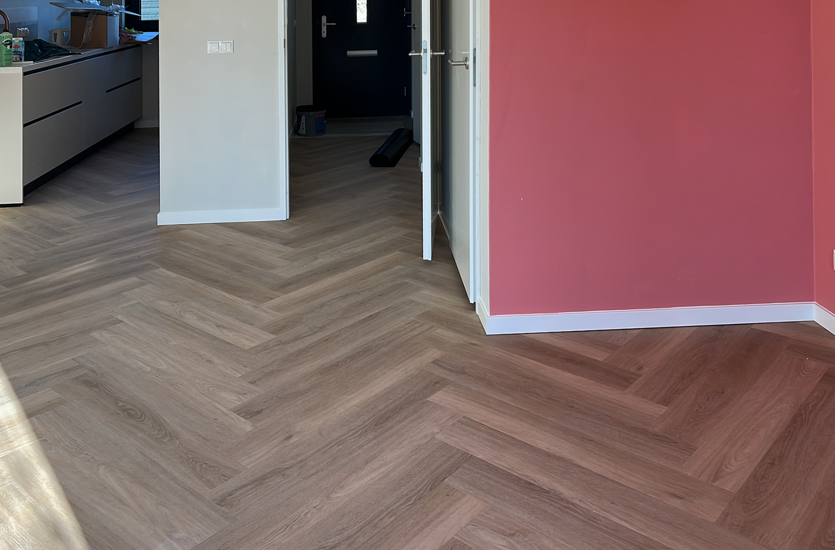 Walvisgraatvloer tussen woonkamer keuken en hal in Winsum