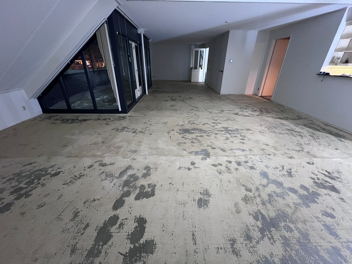 Vrijgelegde ondervloer langs de zwarte glazen pui in Zuidlaren