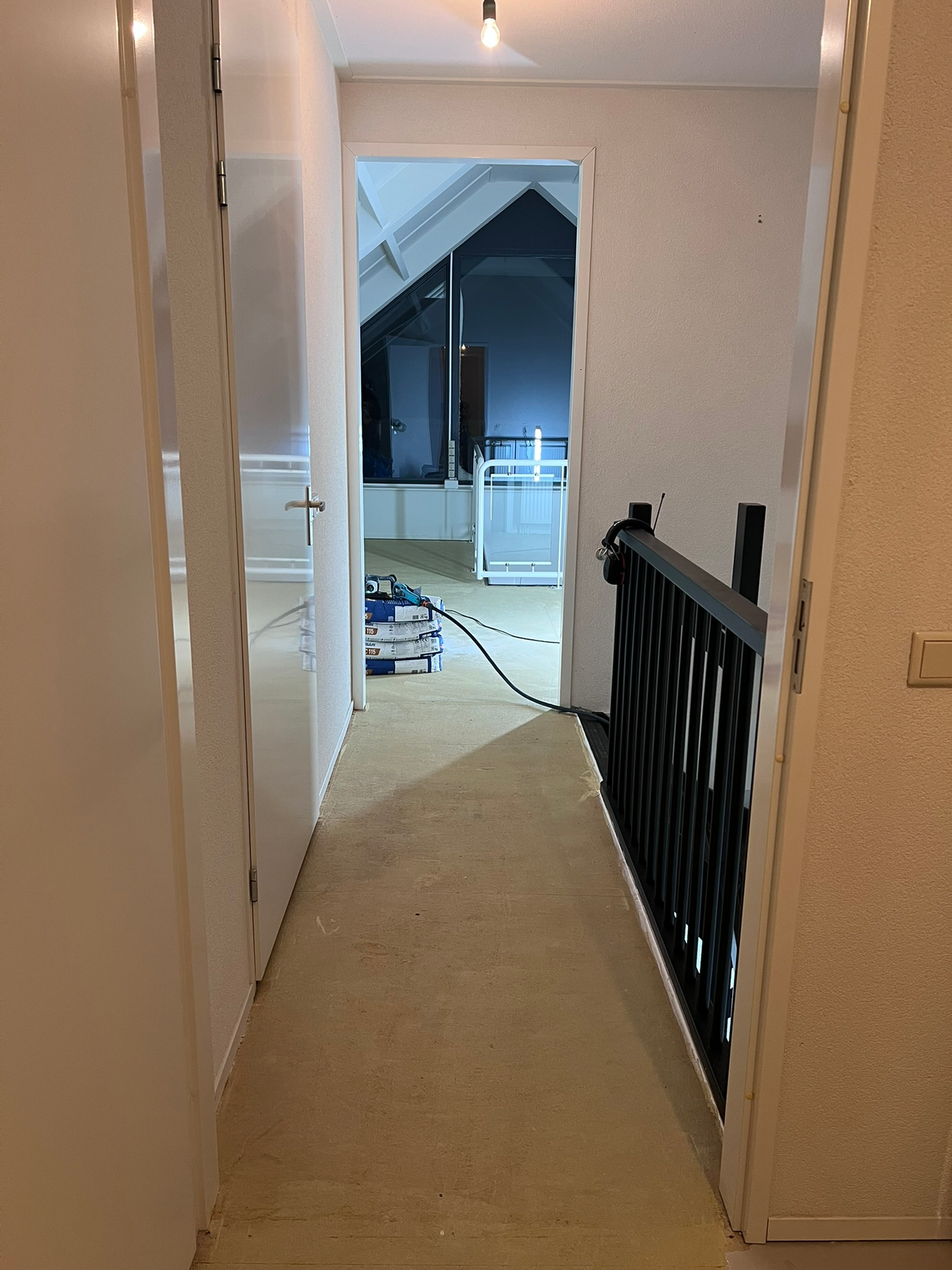 Doorkijk vanuit de gang naar de overloop tijdens het werk in Zuidlaren