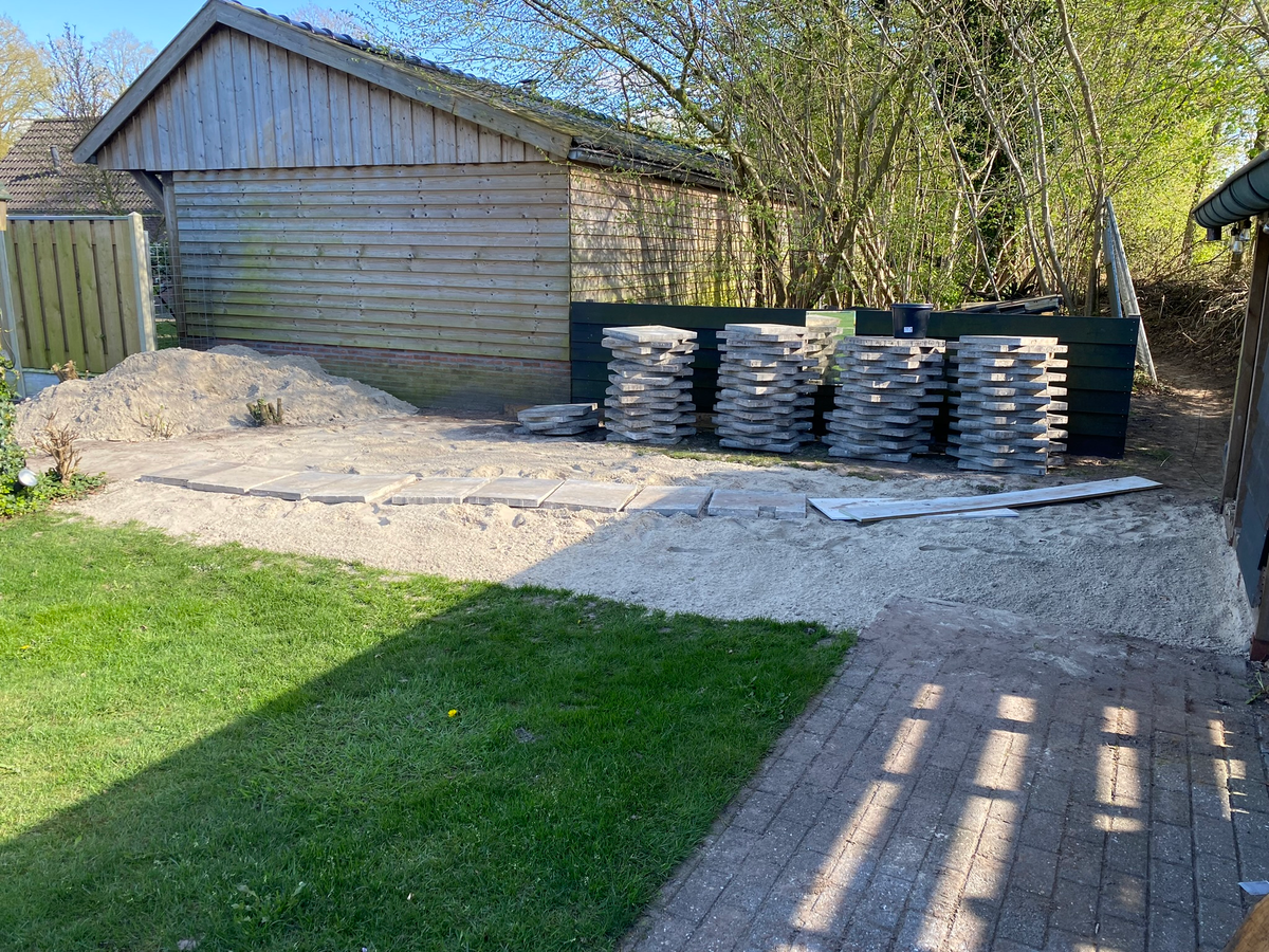 Werkterrein met opgeslagen tegels en zand bij Berkhouwer
