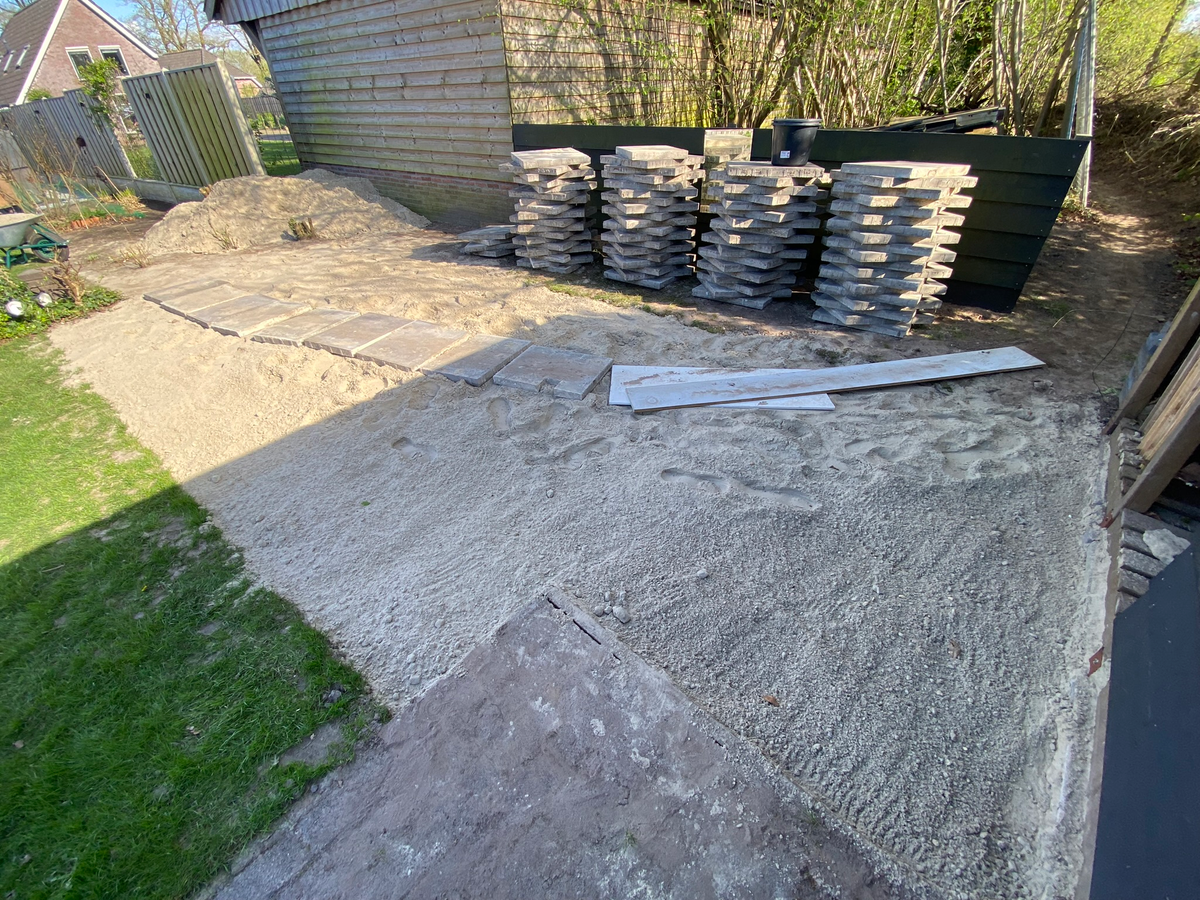 Tijdelijke buitenopslag van tegels tijdens de vloerwerkzaamheden bij Berkhouwer