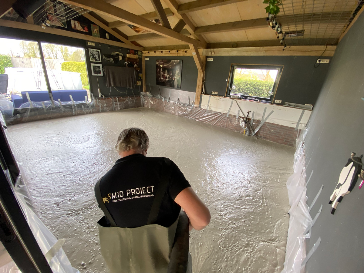 Medewerker van Smid Project bij de vers gestorte ondervloer van Berkhouwer