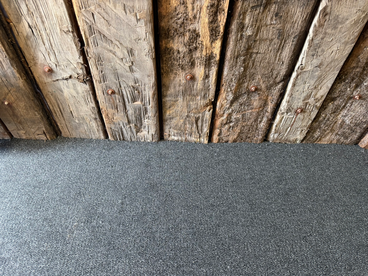Detail van de entreevloer tegen de houten wand bij Buss Terminal