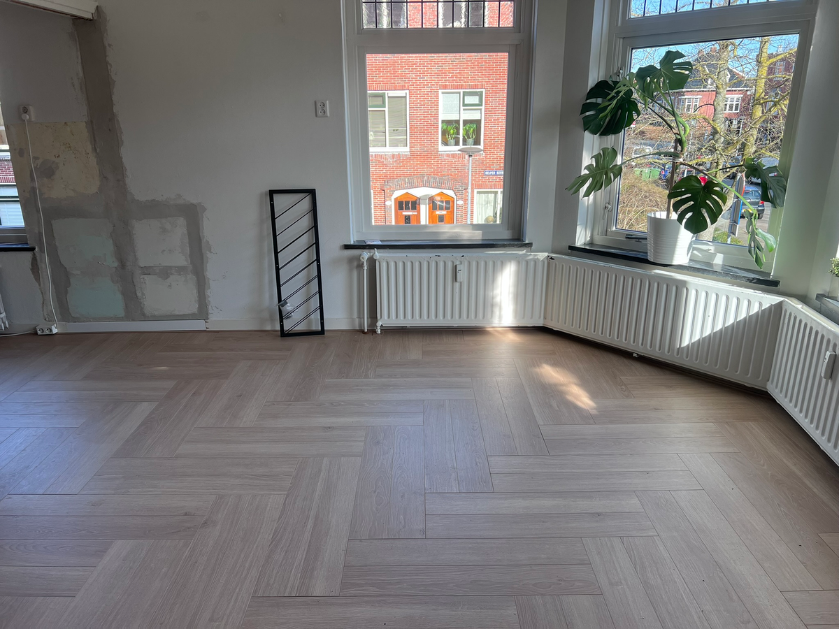 Elleboogmotief bij de ramen en radiatoren in Helpman