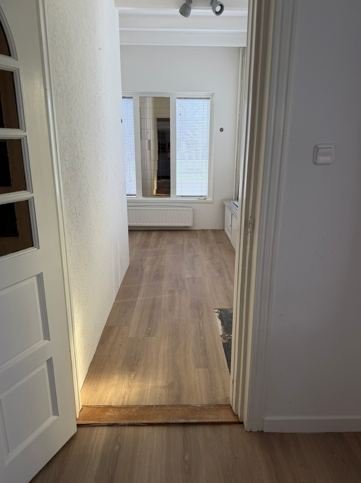 Doorzicht naar de plankenvloer in een aangrenzende kamer in Foxhol