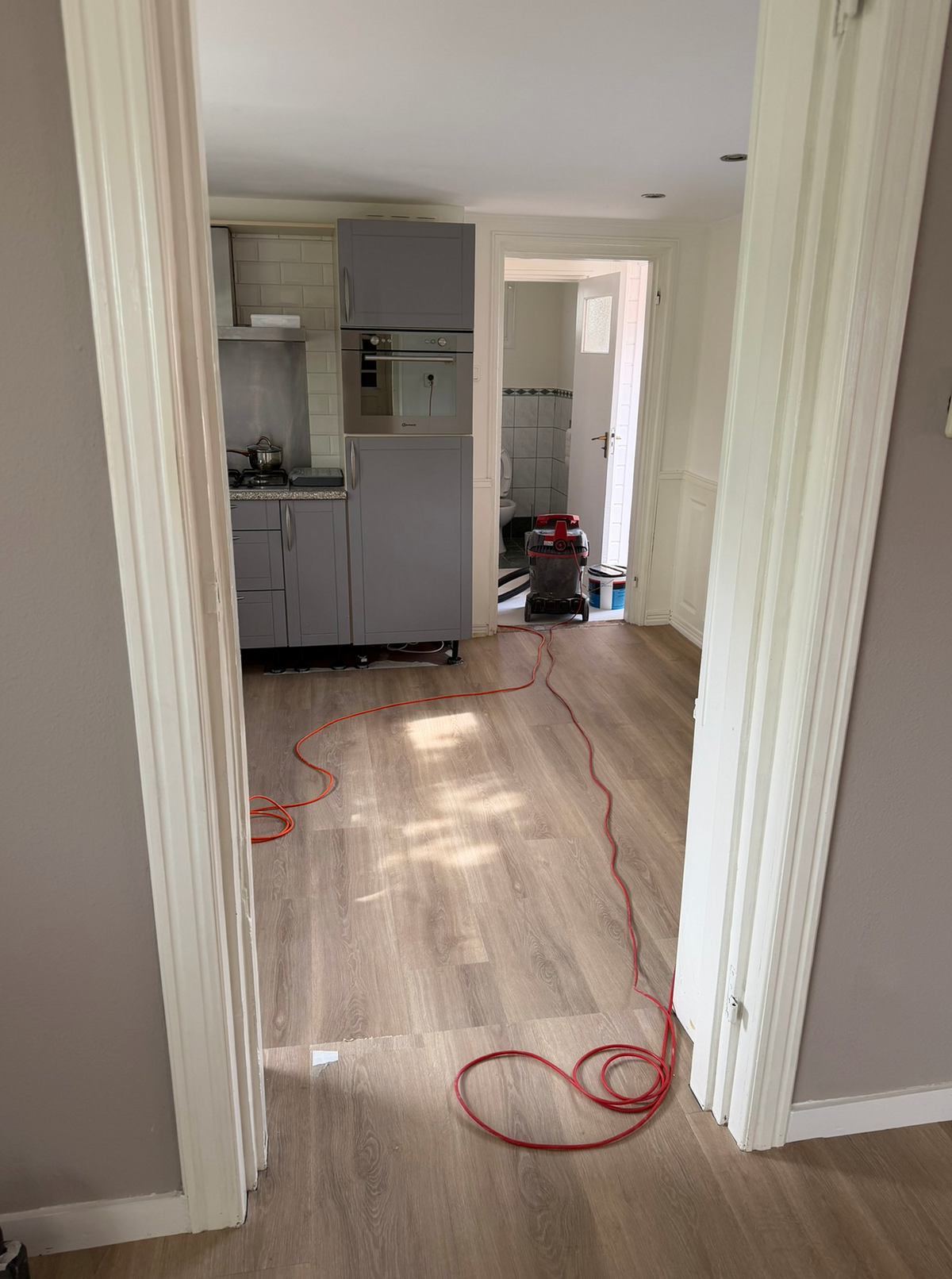 Doorlopende houtlookvloer richting de keuken tijdens het werk in Foxhol