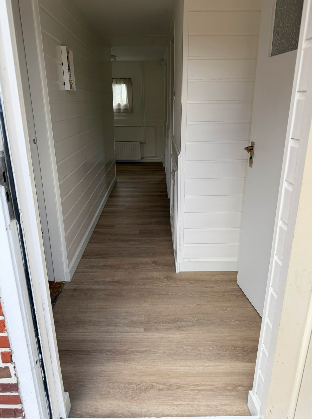 Afgewerkte houtlookvloer in de entree en lange hal in Foxhol