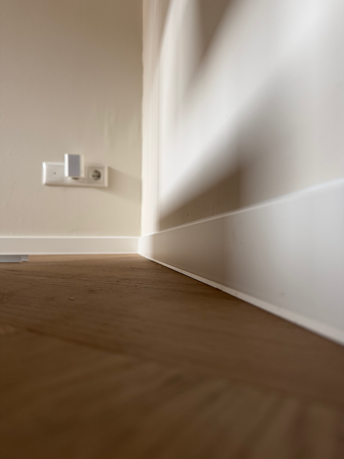 Plintaansluiting met zicht op de wand en het stopcontact