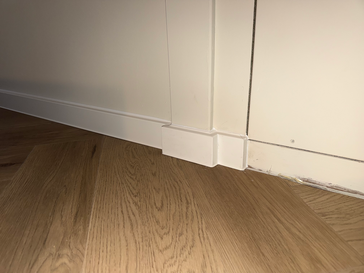 Detail van de vloer en plintaansluiting bij het wandluik