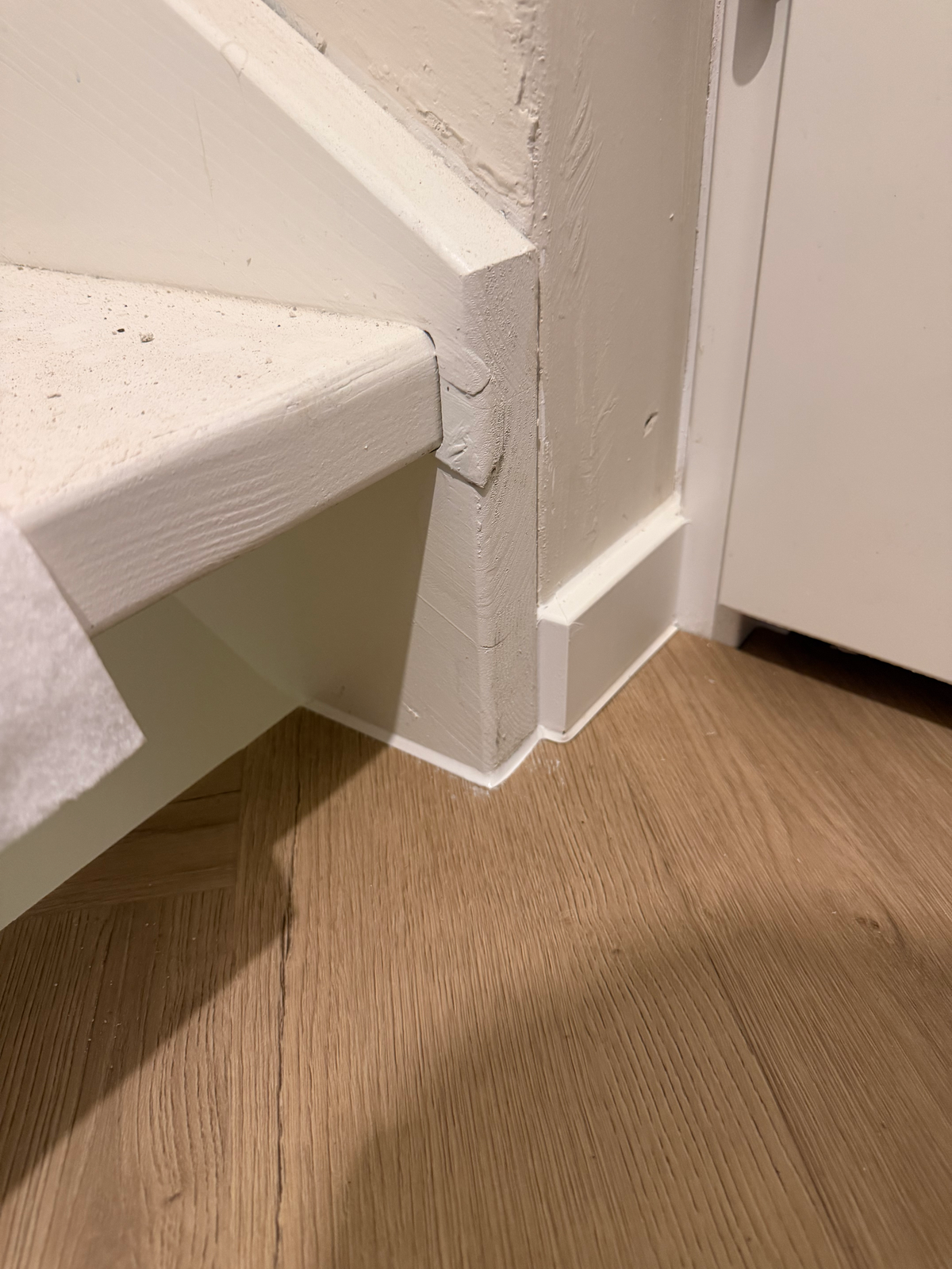Witte plint bij de onderste traptrede