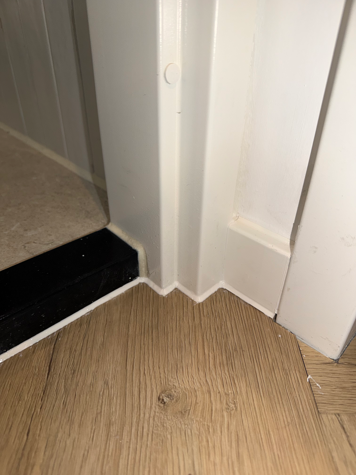Rechter kozijnvoet naast de donkere dorpel