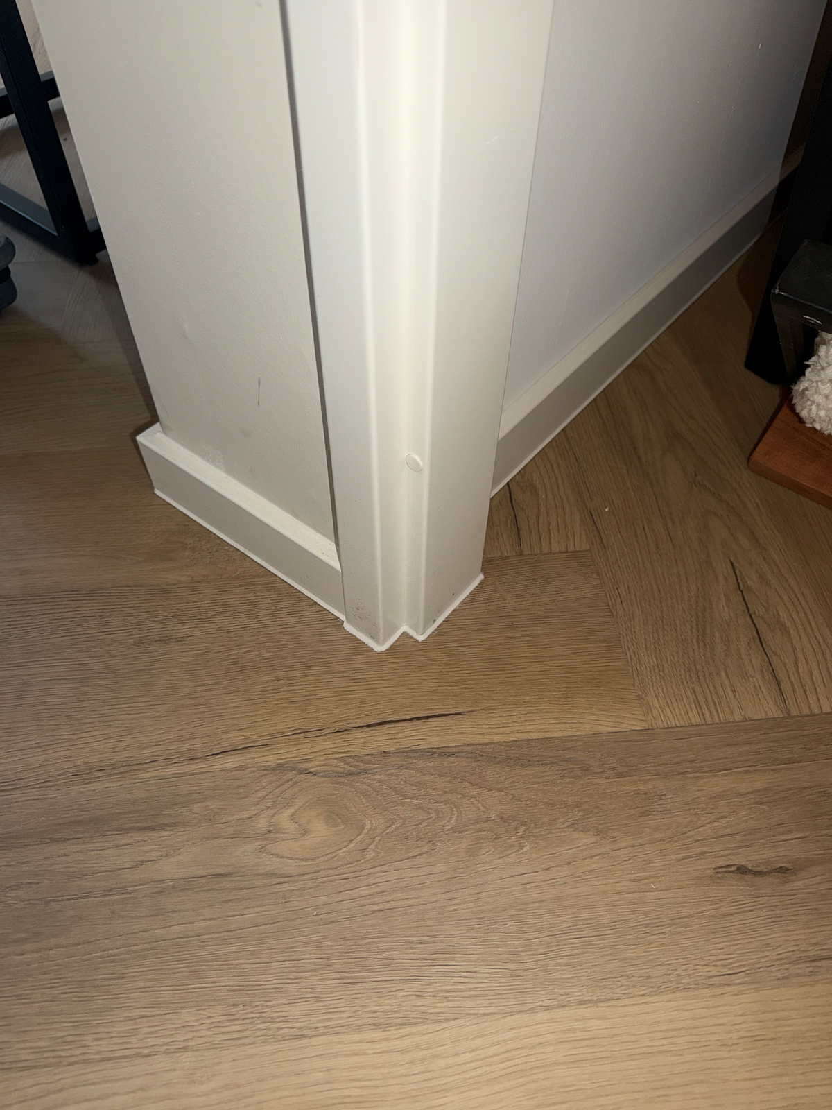 Detail van de witte plinthoek rond het kozijn