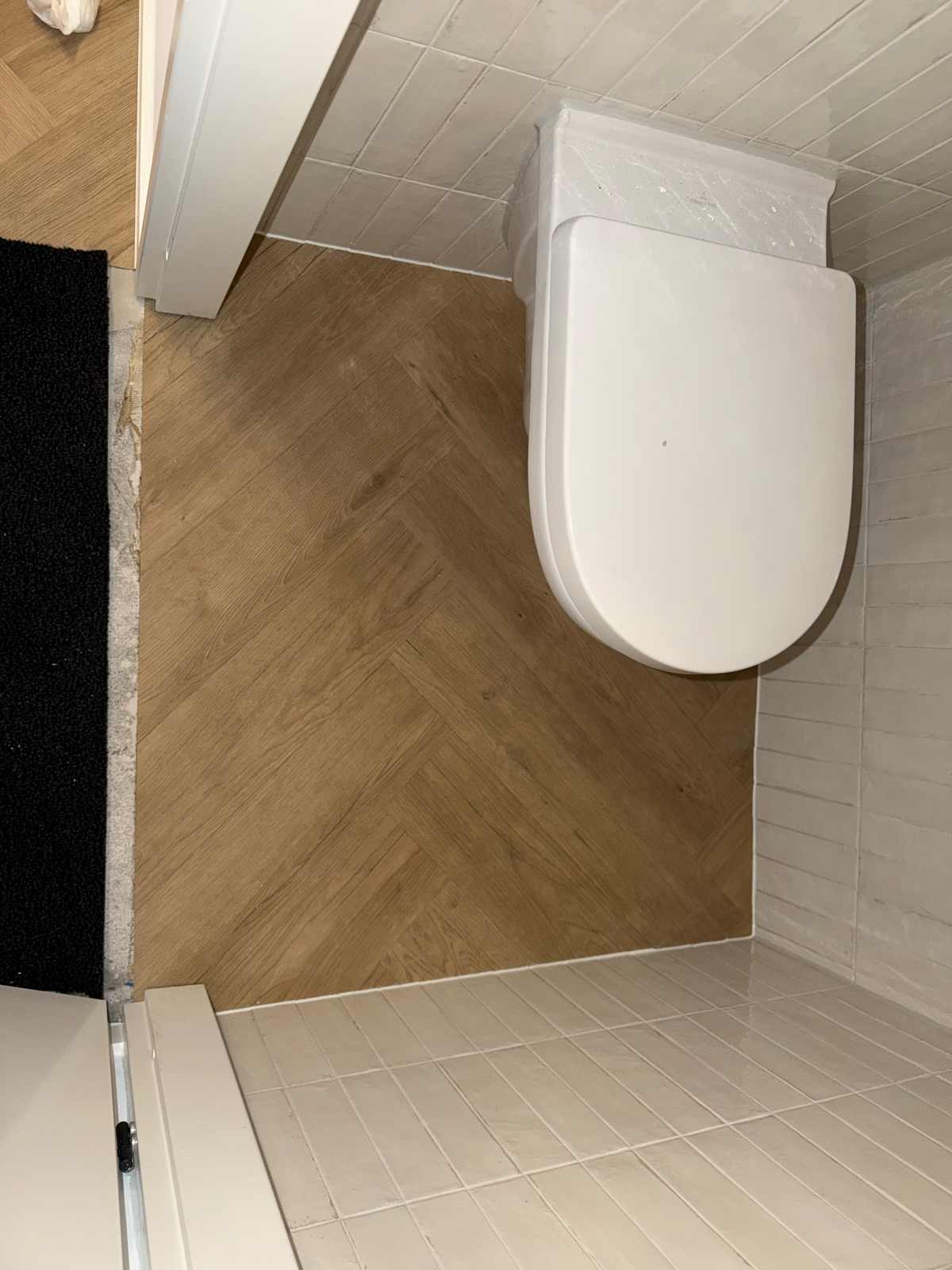 Visgraatvloer in het toilet met aansluiting op de schoonloopmat in Meerstad