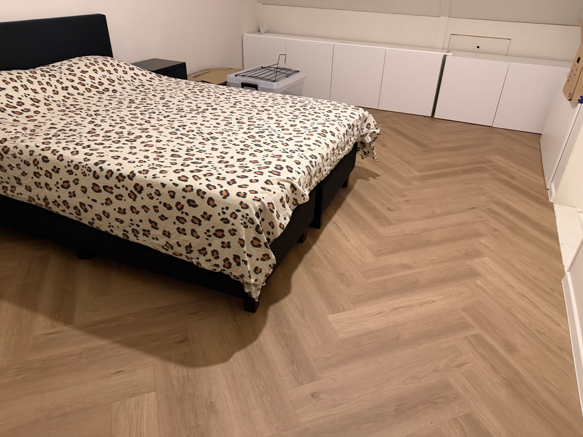 Visgraatvloer langs bed en lage kasten in Meerstad