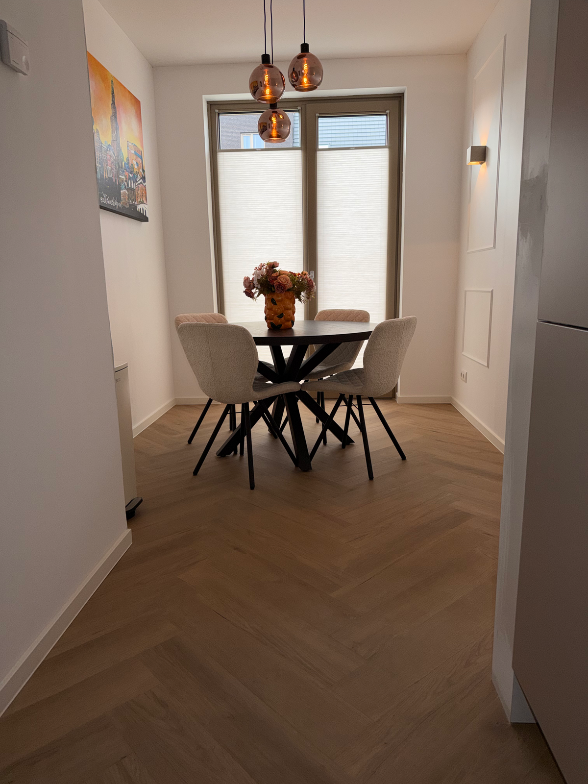 Doorkijk naar de eettafel over de visgraatvloer in Meerstad