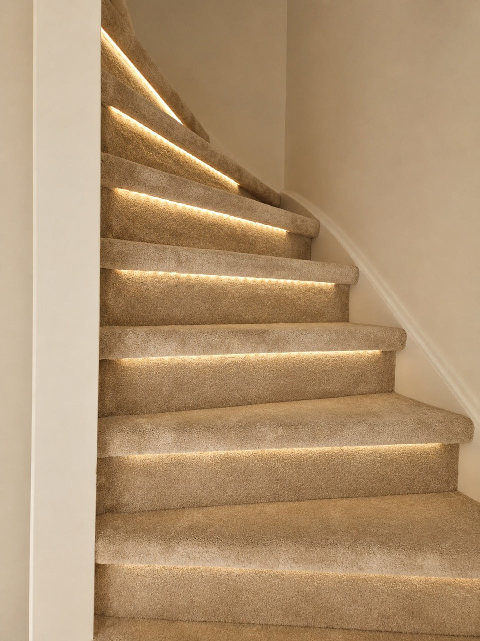 Trap met beige tapijt en warme ledverlichting, geschakeld via een bewegingssensor