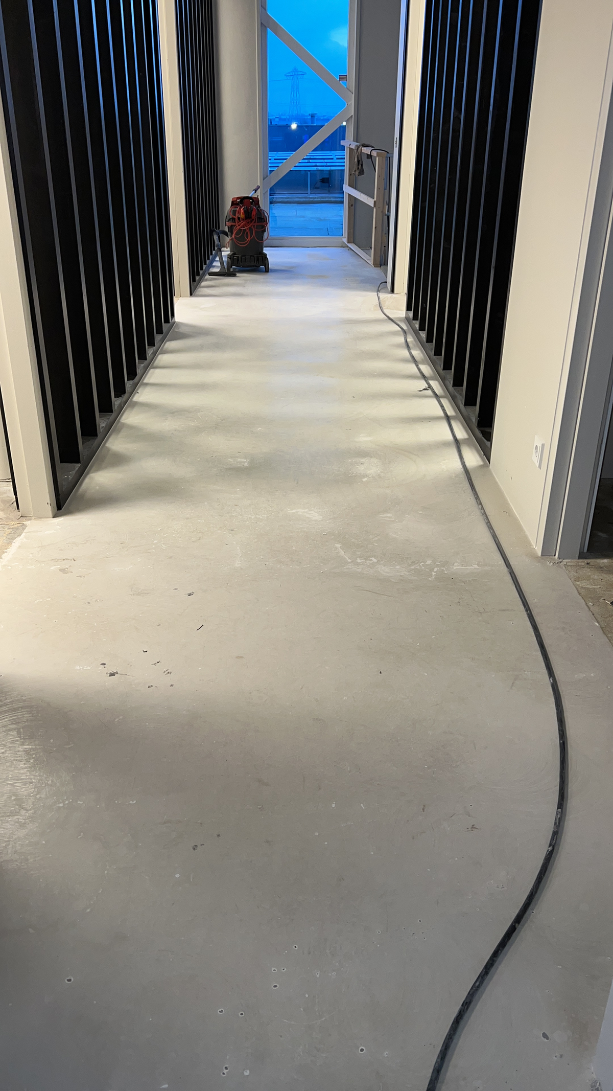 Gang met onbedekte ondervloer tussen de scheidingswanden bij Victron Energy