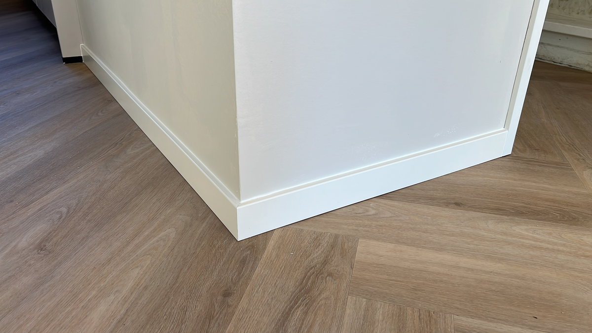 Breed detail van de plinthoek en walvisgraatvloer in Winsum