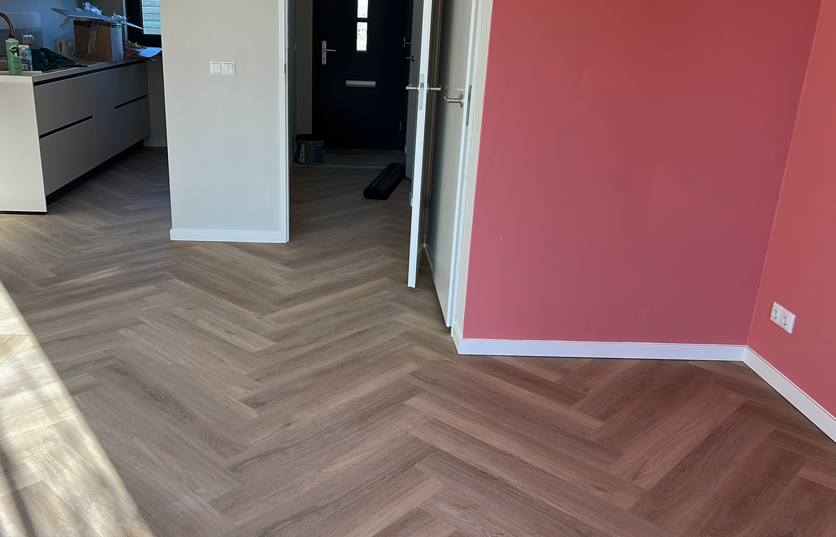 Walvisgraatvloer tussen woonkamer keuken en hal in Winsum