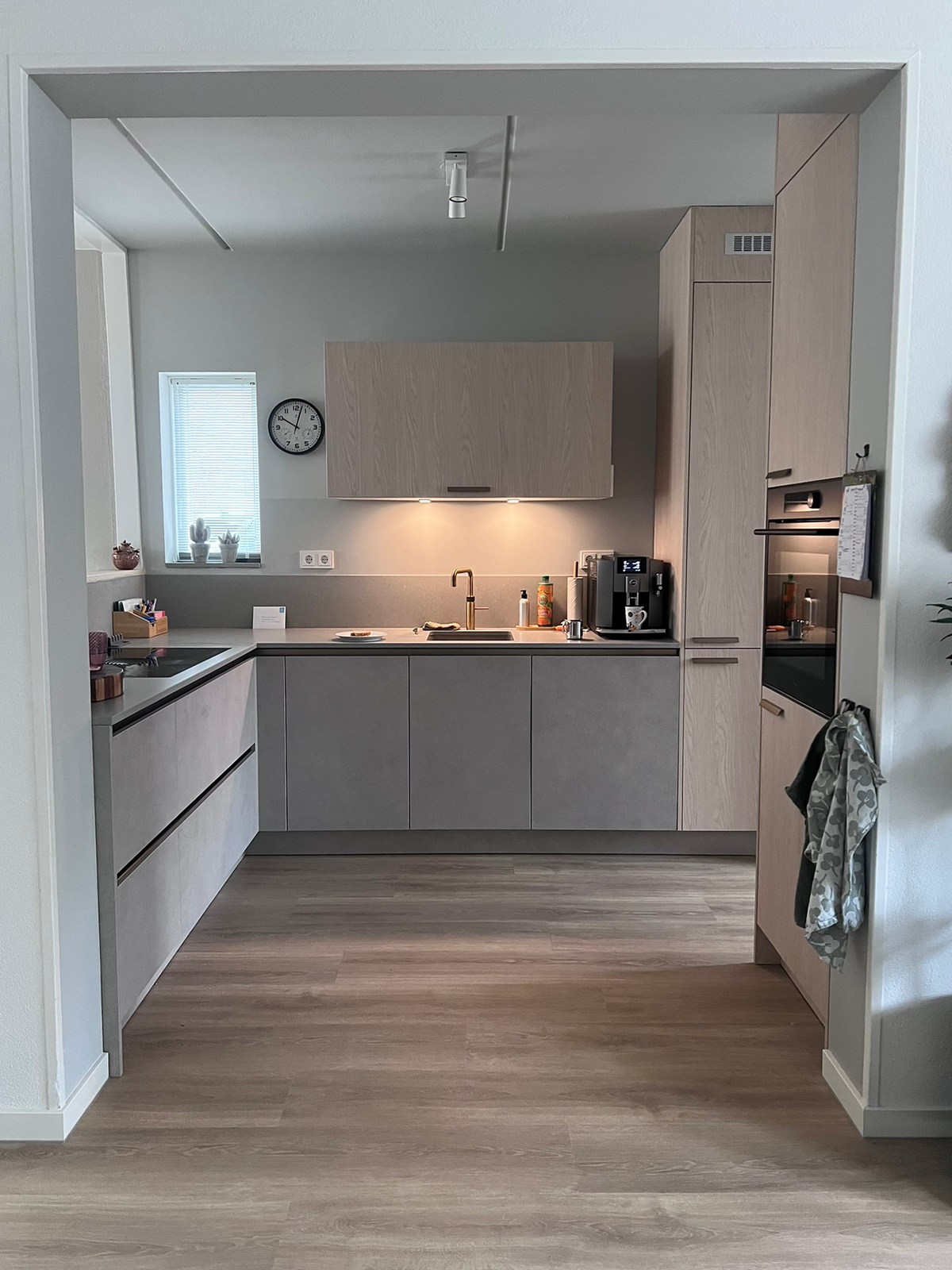 Doorlopende houtlookvloer vanuit de woonruimte naar de keuken in Zuidlaren