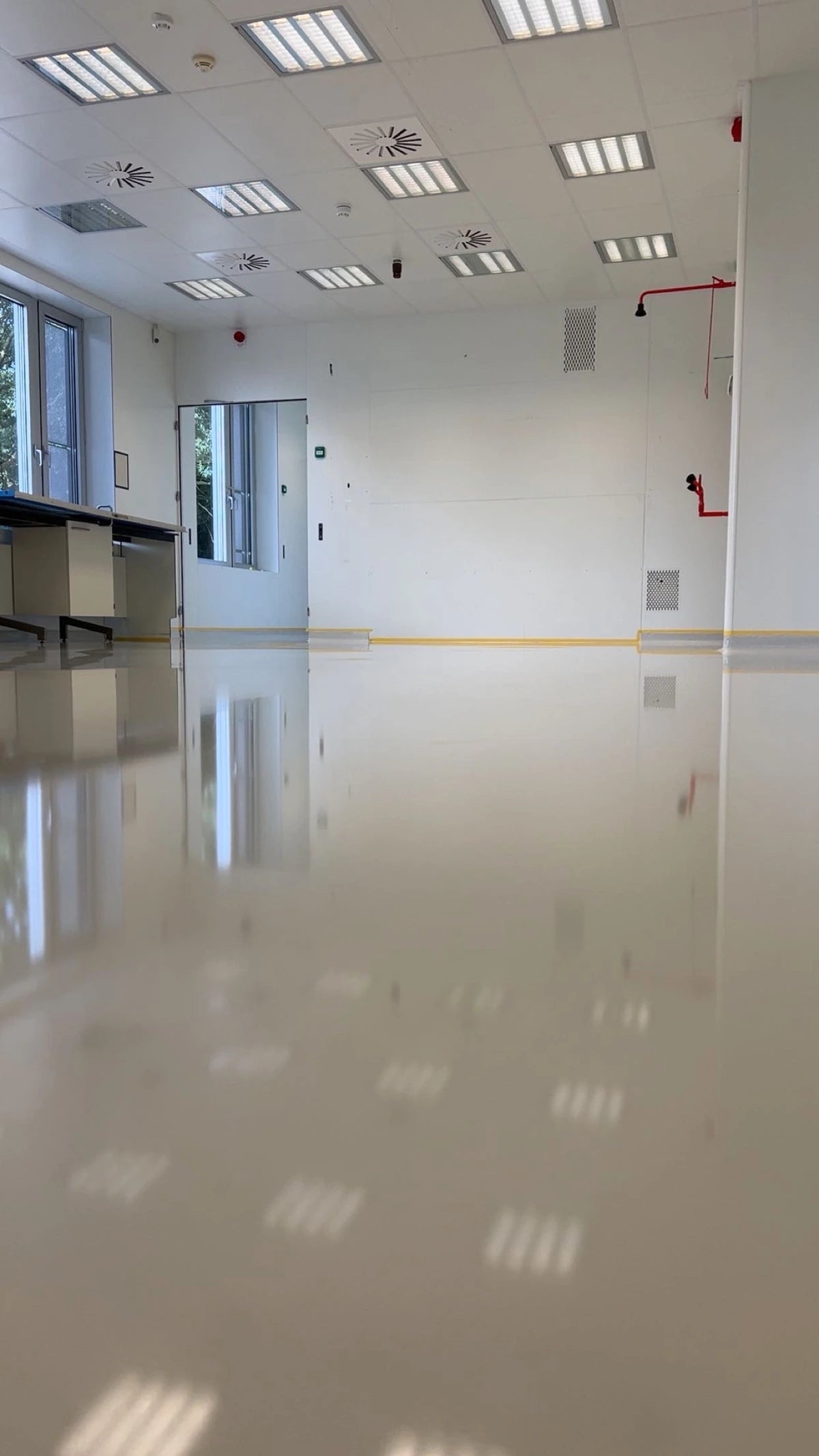 Doorlopende witte gietvloer in de aangrenzende werkruimte in Hoogkerk