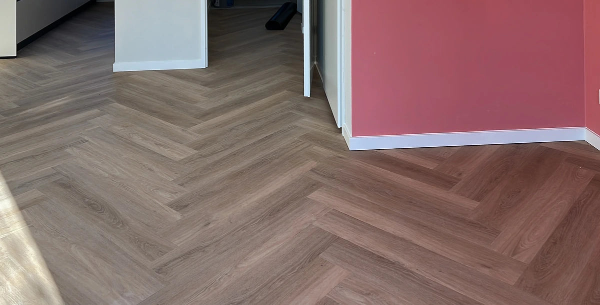 Walvisgraatvloer met witte plinten in de woning in Winsum.