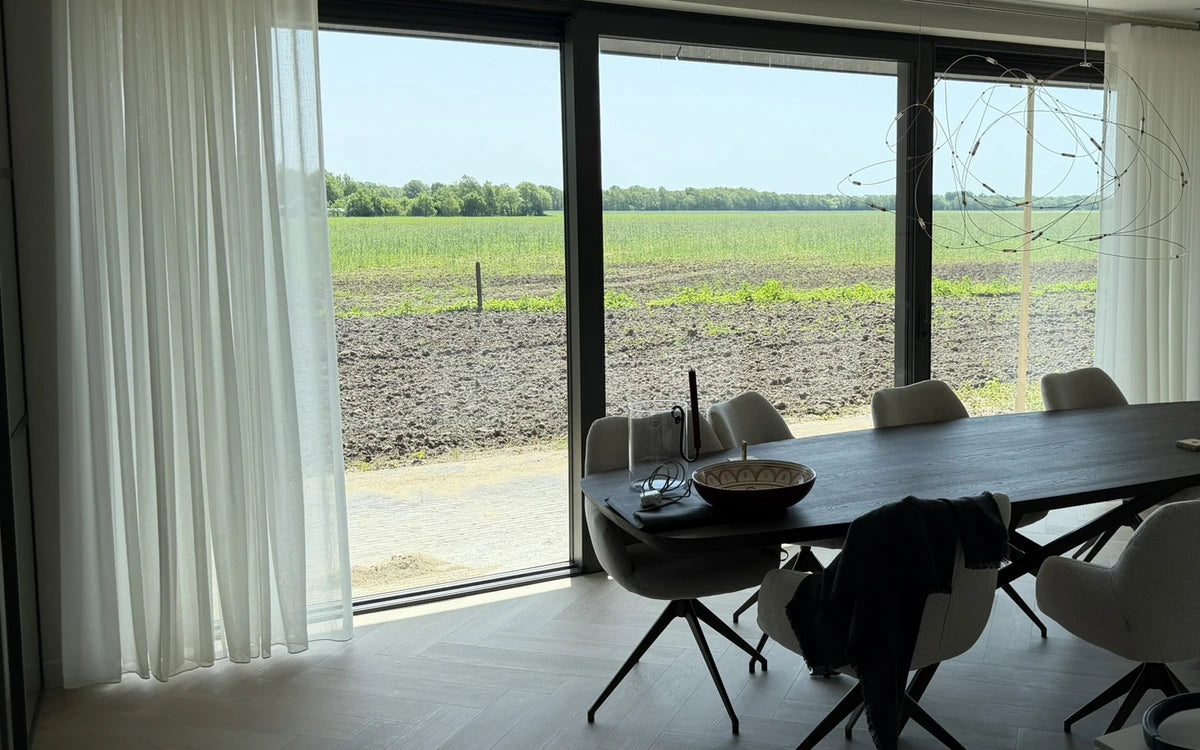 Visgraatvloer en gordijnen bij de eethoek in Tynaarlo