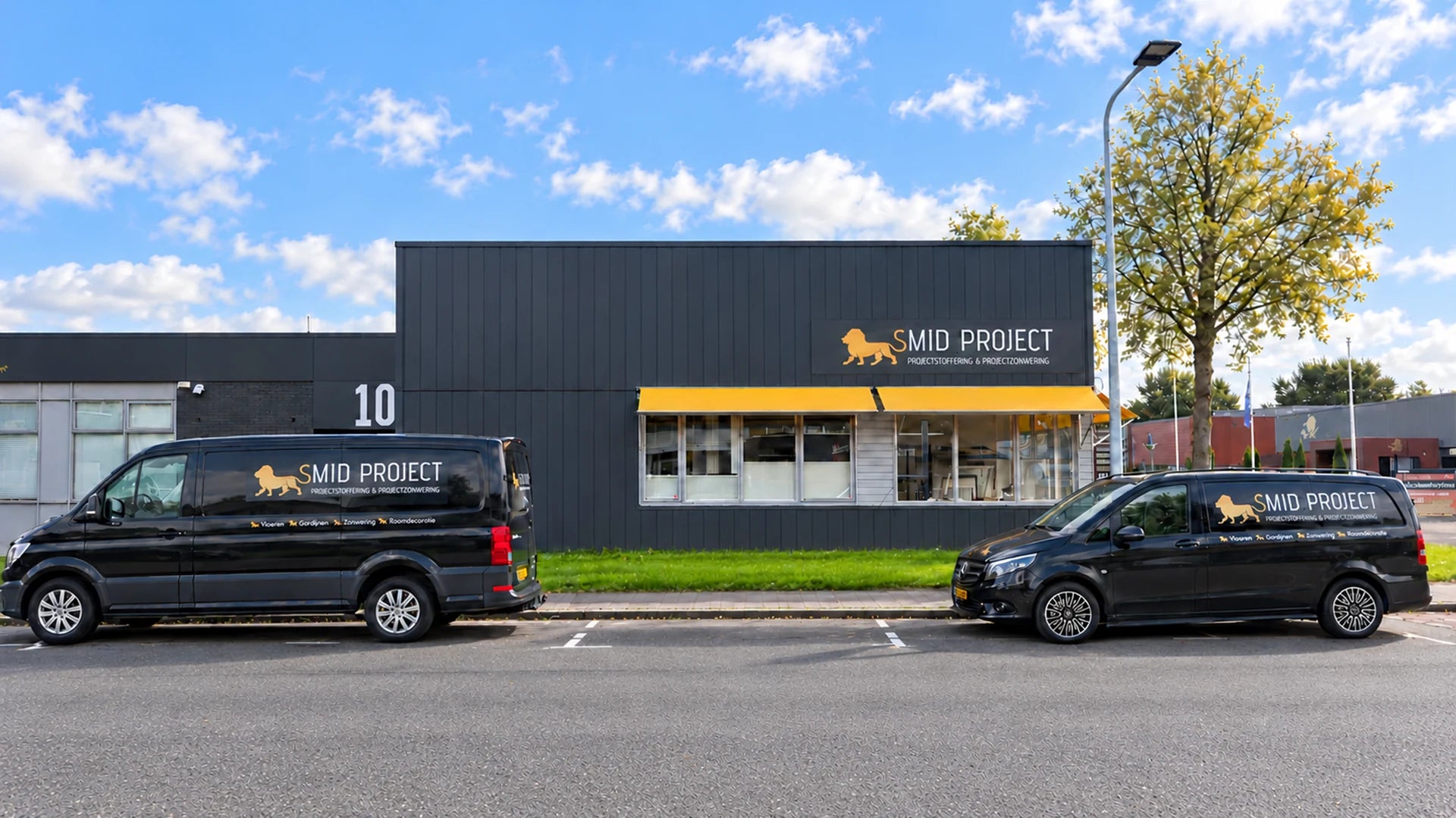 Voorzijde van de Smid Project-showroom in Groningen met twee bedrijfsbussen